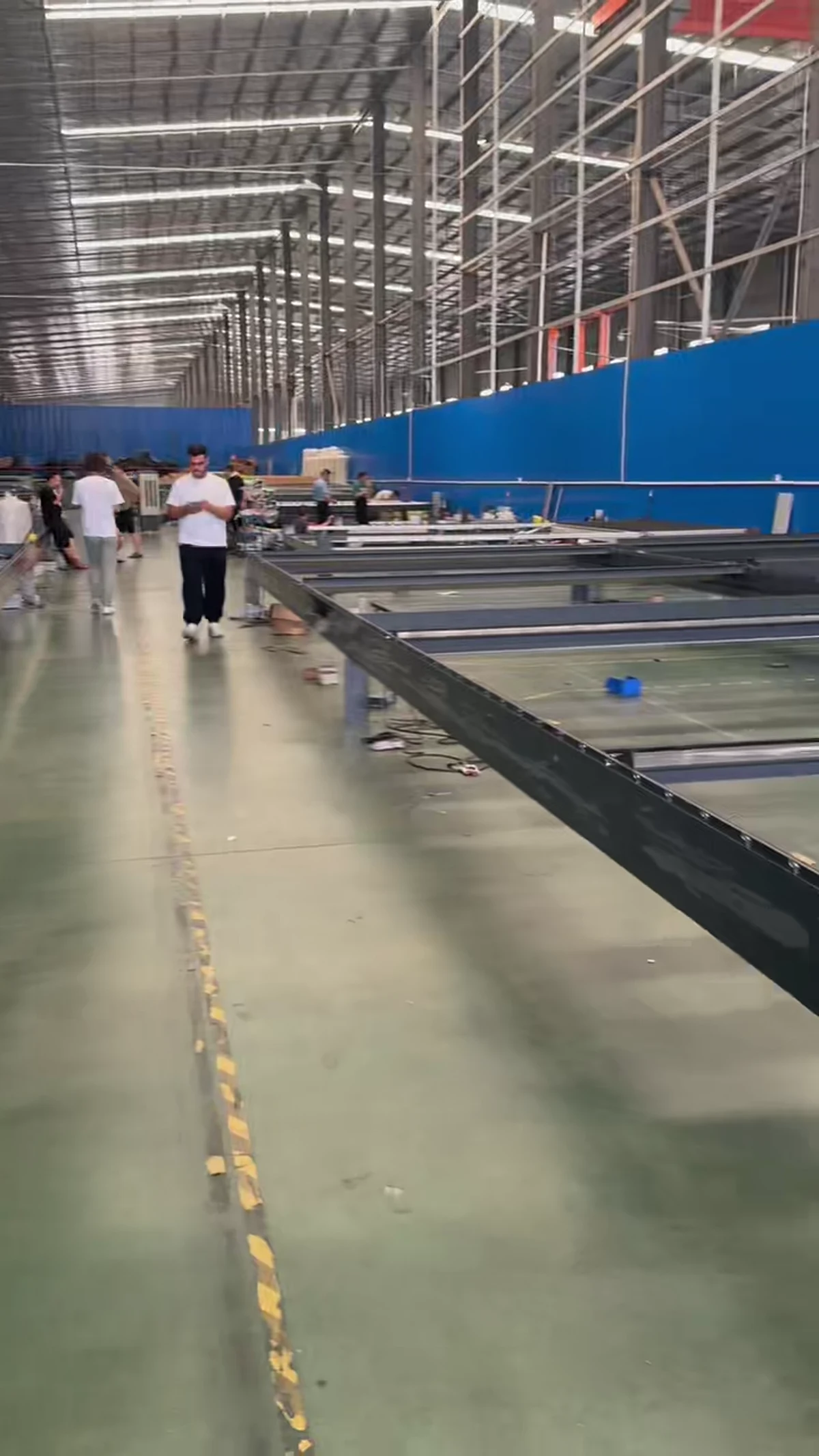 Charcoal pergola frames laid out for pre-assembly inside the factory