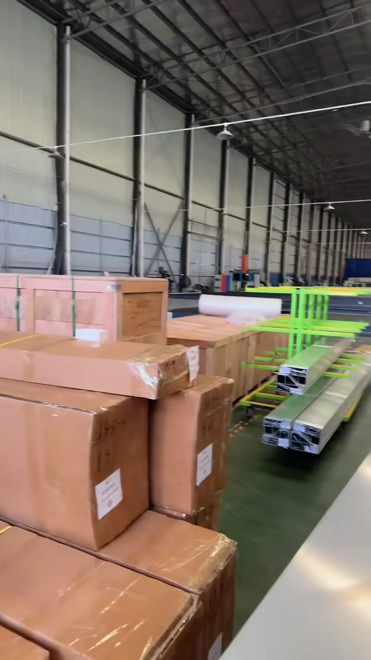 Long pergola profiles and boxed parts organized inside the factory