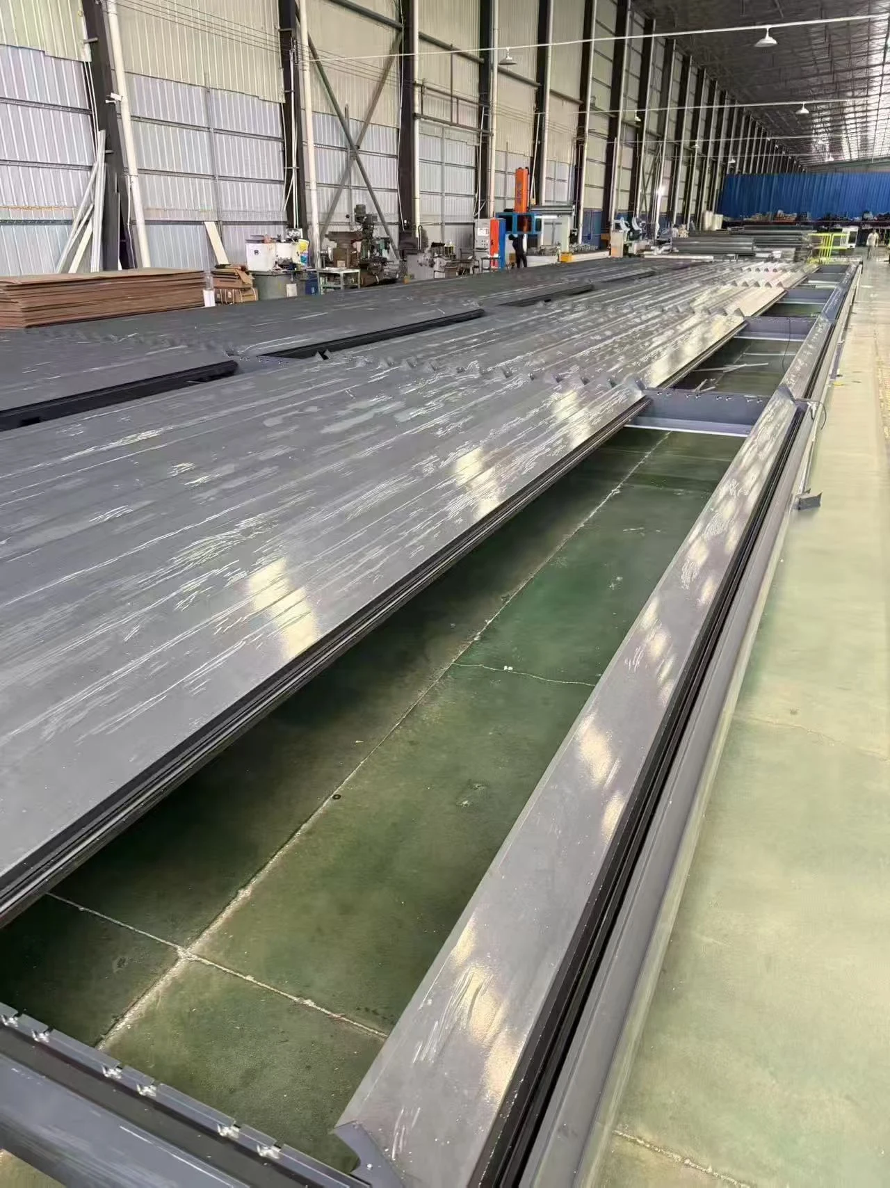 Protected aluminum pergola profiles arranged on factory worktables