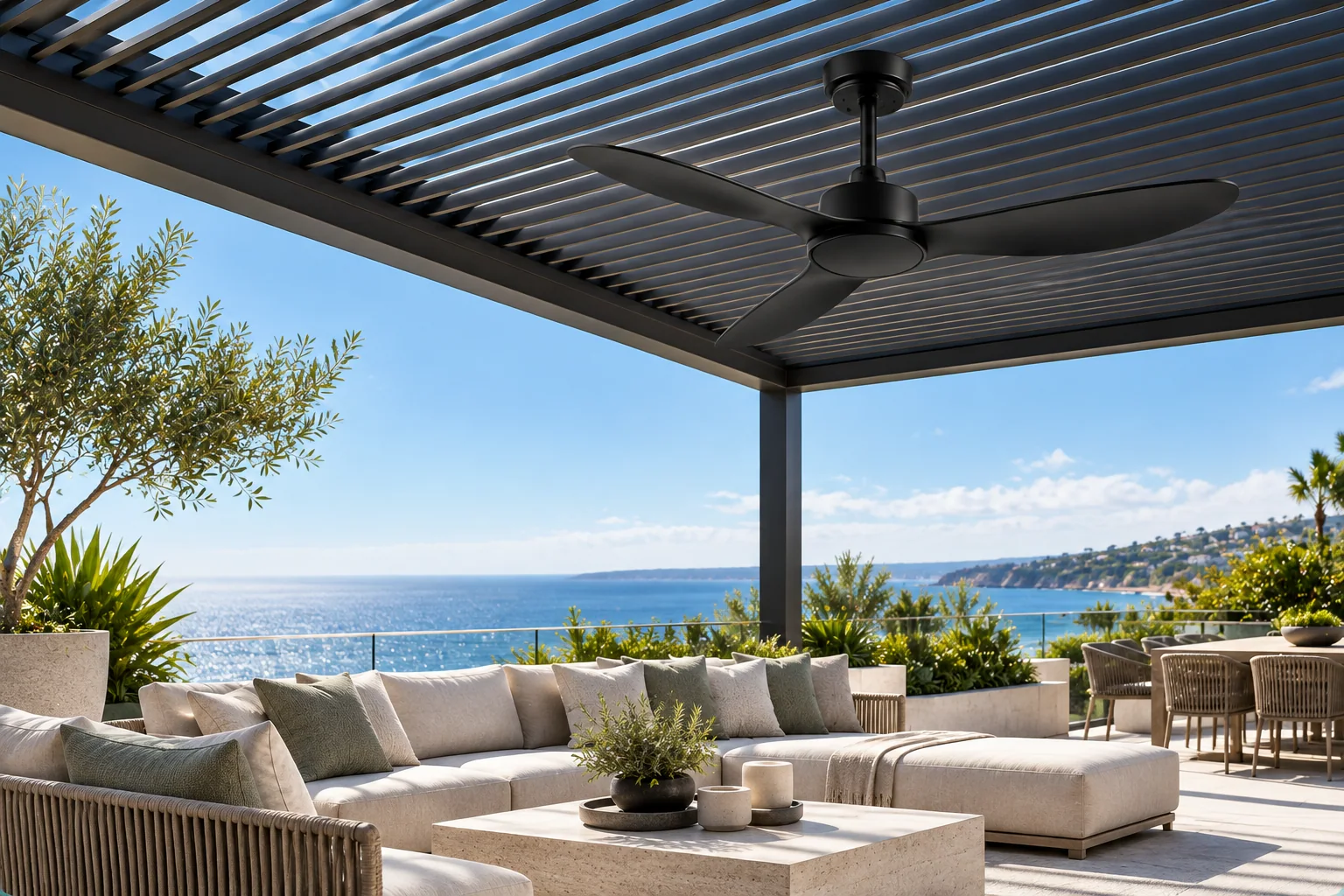 Black three-blade outdoor ceiling fan under a coastal rooftop pergola